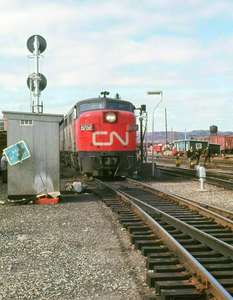 An all MLW A-B-A set of power consisting of FPA2-FPB2u-FPA4 (6752-6858-6780) are ready to leave Capreol on the Montreal section of the Super Continental.  Lots to see in this photo: a half dozen guys roaming around the yard (possibly brakeman trainees), the old water tank, work equipment storage cars, and section gang tool sheds just to mention a couple of items.