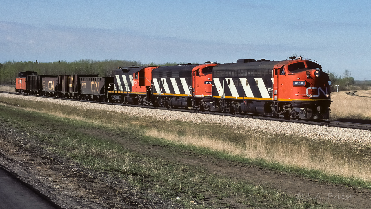 A short unit train is at the north end of the connecting track and will pass by Egremont in about a quarter mile. Caboose 79315 brings up the rear.
