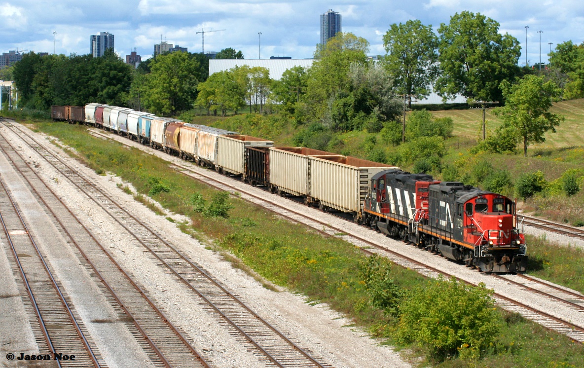 CN X540 with 7038 and 4130 arrives at the interchange in Kitchener on the Huron Park Spur with cars for Canadian Pacific. September 6, 2021.