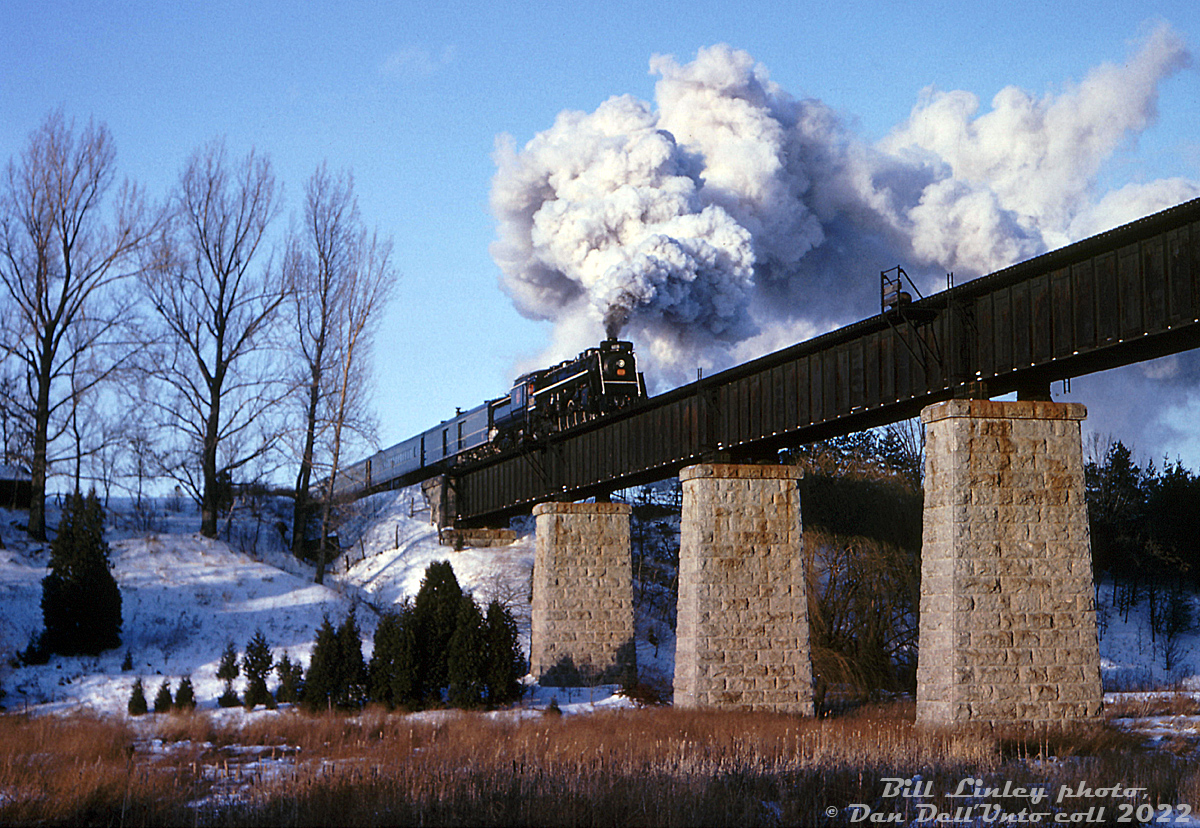 Canadian National Northern 6218 makes its first winter fantrip debute! Operating on the Upper Canada Railway Society's forth annual winter steam excursion held on January 30th 1965, 6218 took railfans on a tour of the new "Toronto Bypass" line (CN Halton and York Subs), and is seen here doing a run-by westbound over the bridge at Stewarttown, on the former Milton Sub portion of the line (Georgetown to Burlington).

According to an old UCRS newsletter, the excursion's routing was departing Toronto's Union Station and heading up the Bala Sub to Doncaster, turning west onto the York Sub (with runpasts at Yonge St. and Dufferin St.) heading westbound through Snider onto the Halton Sub (runpasts at the Humber bridge and Claireville overpass), stopping for coal/water at Brampton, and continuing on to Stewarttown for a runpast. Problems with the feedwater heater cut the trip shorter than intended, and the train proceeded south to wye at Burlington and head back to Toronto via the Oakville Sub.

In addition to it being the 6218's first winter fantrip excursion, it was apparently the first "revenue" passenger train operated over the new York & Halton Subs, and the first time a large-sized engine operated between Georgetown and Burlington over the former Milton Sub.

William (Bill) R. Linley photo, Dan Dell'Unto collection slide.