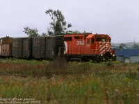 CP GP35 5007 prowls the weedy <a href=http://www.railpictures.ca/?attachment_id=47318><b>Saugeen Junction</b></a> with two Maine Central boxcars and a 434000-series van in tow, coming off the Owen Sound Sub onto the Walkerton Sub for the trip westward. The short train had come north from Streetsville Junction, and was enroute to Durham where the two MEC boxcars would be spotted at the ramp track in the yard, and another empty MEC boxcar would be lifted for the trip south. Dwindling branchline traffic would very soon doom the Walkerton Sub to abandonment in 1983-84, and the Owen Sound Sub to abandonment in 1995.<br><br>The track in the foreground is the wye track, spanning the north end between the Owen Sound and Walkerton Sub mainlines. Track diagrams note a few short storage tracks present off the Walkerton Sub inside the wye (probably disused by then, and hidden by the weed growth). What appears to be an old farmhouse or shed in the background still exists in present times.<br><br><i>Roger Heed photo, Dan Dell'Unto collection slide (with thanks to Ron B. for information!).</i>