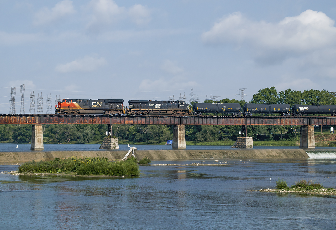 With a 10mph speed restriction in place due to the heat, and some foreign power trailing, CN L502 makes its way down the branch to Garnet Yard slowly crossing the Grand River at Caledonia.