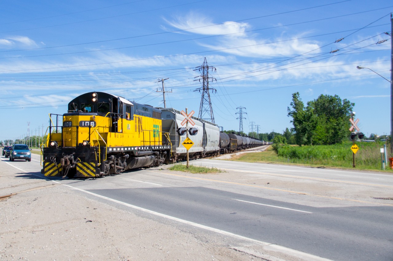 In a rather impressive display of EMD muscle, a lone GP9 lugs 50+ cars of manifest towards ETR Ojibway Yard on a sunny July morning in the south end of Windsor. Once at Ojibway, the train will be disassembled and individual cars will be delivered to customers in the area.