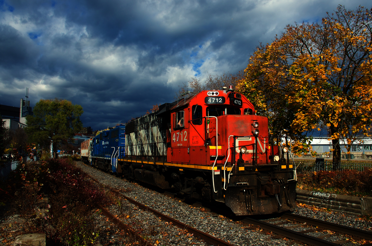 The sun holds out just long enough to get a sunny shot of CN 4712 & CN 4904 leaving the Port of Montreal with a transfer as a bit of foliage remains.