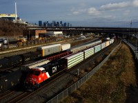 CN 3305 (recently rebuilt from Dash9 CN 2563) is leading CN 305 as it passes CN X306, as well as cars parked on the Freight Track and Track 29. 
