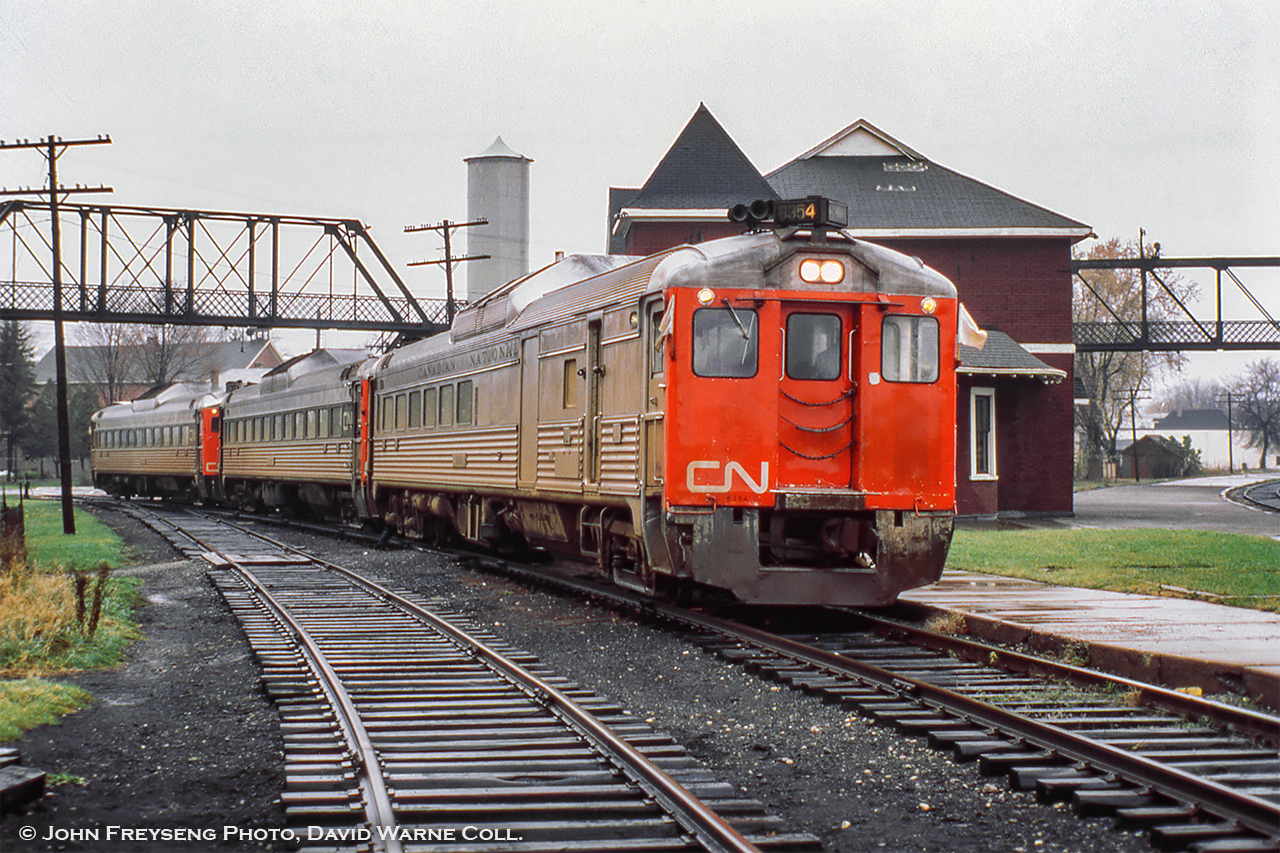 Last CN Passenger service at Palmerston, part 3.  Three CN railiners meet on the Newton Sub platform at Palmerston, preparing to go their separate ways for the final time.  In the middle, an RDC-1 from Owen Sound (formerly train 672) was the first to arrive at 0655h, followed by RDC-1 6118 from Kincardine at 0700h (formerly train 662, furthest from the camera).  The final movement to arrive at 0705h, RDC-2 6354 from Southampton (formerly train 668), has been added to the front of the Owen Sound car awaiting departure.  In just a few minutes at 0715, passenger service will cease as Extra 6354 departs for Toronto via Guelph (former train 658) and Extra 6118 departs for Stratford (former train 663).John Freyseng Photo, David Warne Collection slide.