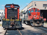 CN SW1200RS 1364 and GP9RM 7044 are viewed outside CN’s MacMillan Yard diesel shop in Vaughn, Ontario during a late summer afternoon. At the time, CN 7044 was a Vancouver assigned GP9RM and was either in Toronto after being re-assigned or was at the Toronto shop for required work. 

