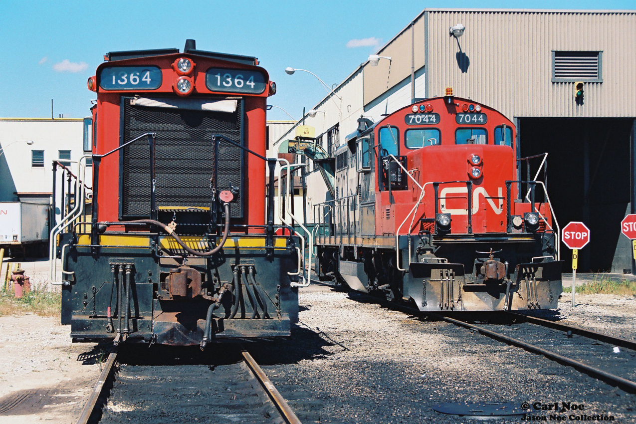 CN SW1200RS 1364 and GP9RM 7044 are viewed outside CN’s MacMillan Yard diesel shop in Vaughn, Ontario during a late summer afternoon. At the time, CN 7044 was a Vancouver assigned GP9RM and was either in Toronto after being re-assigned or was at the Toronto shop for required work.