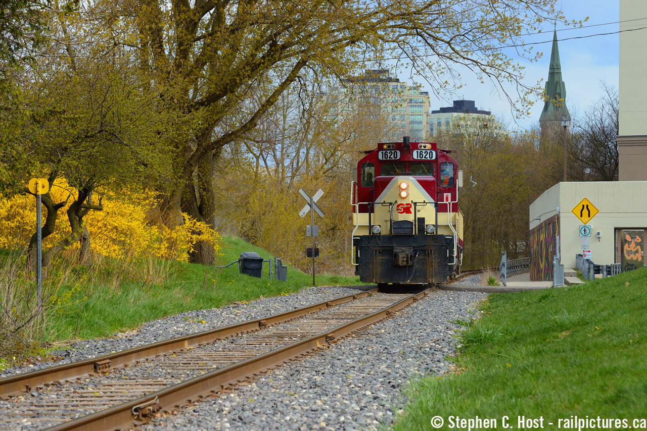 OSR Job 2 is passing through downtown Guelph with the spire of St. George church in the background. Behind the light power move is where the station platform was for Guelph's 2'nd station (1930's to 1980's when the station was removed for a gaudy looking rental highrise)