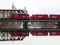 Rolling across the Otonabee River bridge (built 1913) in downtown Peterborough, tri-weekly CP train T08 is on its way to Havelock and Blue Mountain with a short, 8 car consist.  Power is a pair of GP20C-ECO's 2231, 2270  and GP38-2 3042.  In the background is the Quaker Oats mill. 

