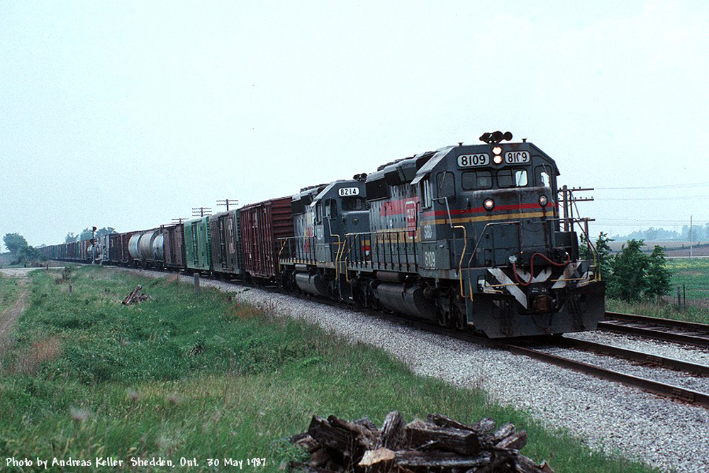 An Eastbound CSX train rolling through Sheddan, ON behind a pair of Seaboard System SD40-2's 8109, and 8214 on May 30th, 1987. 8109 was built as L&N 8109 in May of 1980, and would go on to become CSXT 8109 before being retired sometime in the 2010's. 8214 was built as L&N 3586 in September 1977, and is presently still on roster as CSXT 8214