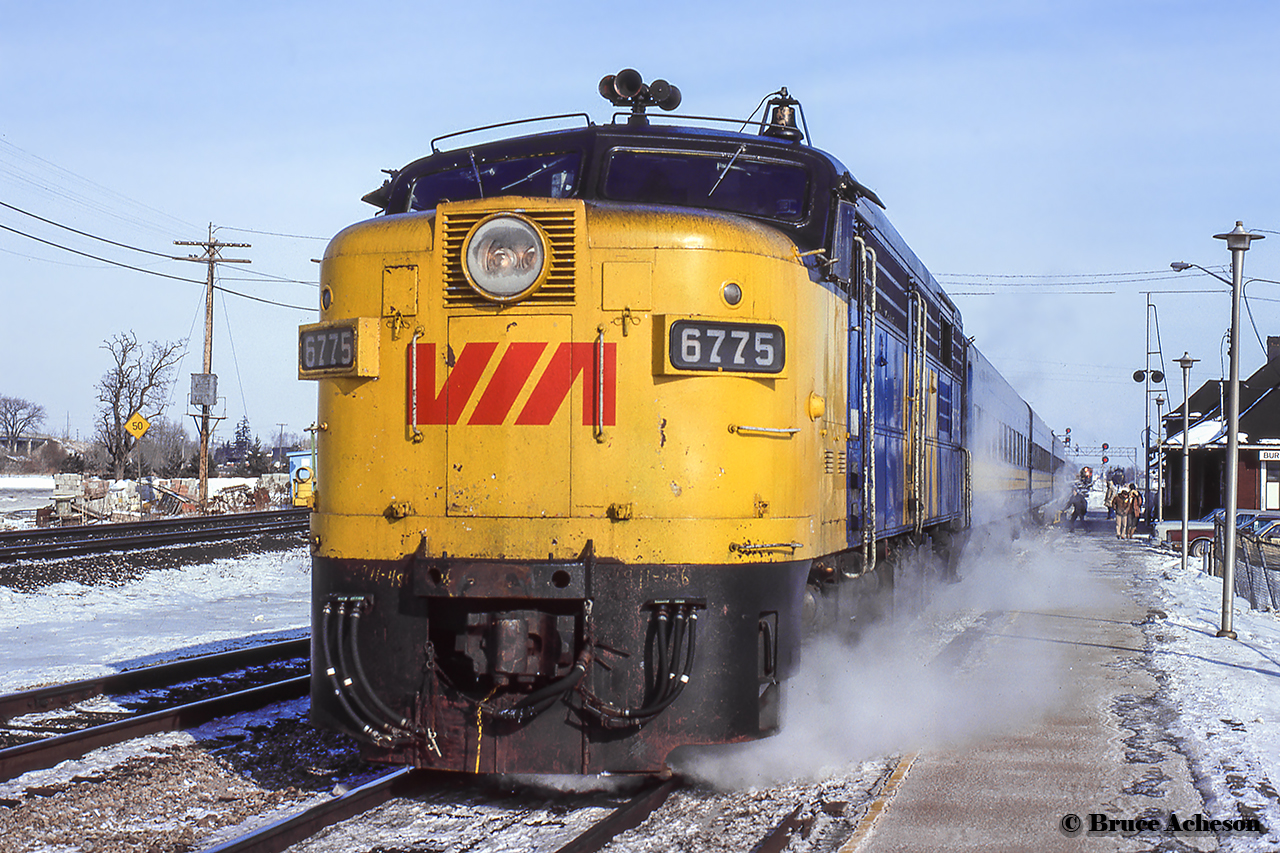 Steam heat seeps into the crisp winter air during 73's stop at Burlington West.  Note the CN train waiting in the distance.
