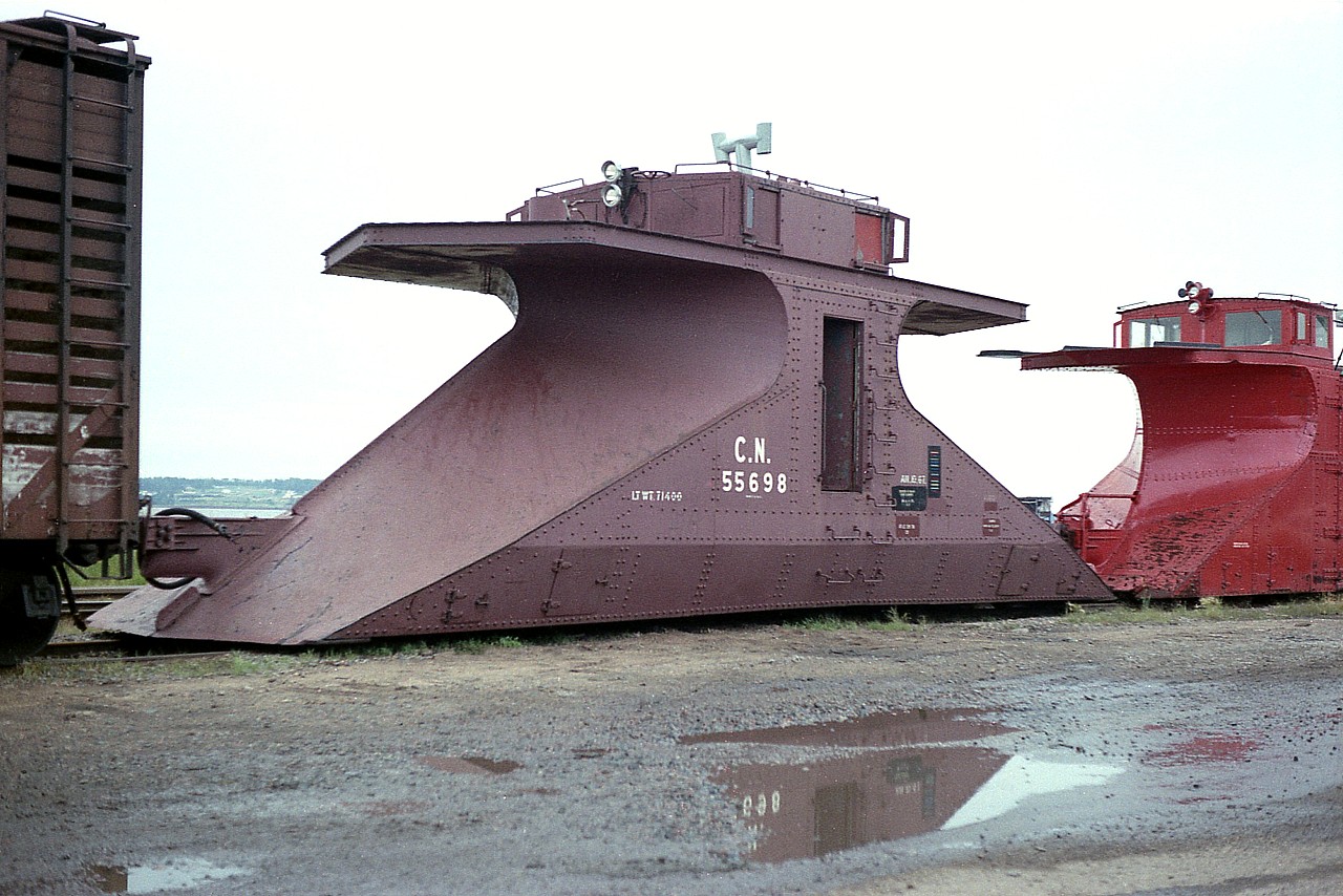 Something rarely seen.  Only four of these double-ended snowplows were ever built for CN. Transcona Shop in Winnipeg constructed them back in 1939. They were numbered 55696 to 55699. The purpose of this design was for snow clearing on branchlines where there was no place to turn the train, so the power just ran around the plow  and the snow clearing equipment just headed back the way it came. I'm not sure where they were stationed, but a good bet would be on Prince Edward Island, where I found this one in a storage line at Charlottetown. It was the last survivor, and eventually ended up at the Salem and Hillsborough Railroad (SHRR) in Hillsborough New Brunswick, where it received some restoration and was repainted and lettered "S&H".