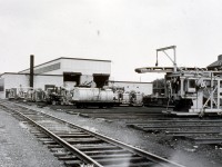 Following up on an earlier post showing the new CN Danforth Work Equipment Shop that opened on June 5, 1956.
 
http://www.railpictures.ca/?attachment_id=42224

Here is a view from the rear of the new shop that same opening day.

Tucked between Main Street and Victoria Park Avenue, the CN Danforth Work Equipment Shop & Yard occupied the grounds that is now all townhouses. This new state of the art facility replaced a much older and smaller facility on the same property. The old shop was built on a foundation that had the large doors into the building at boxcar door/flatcar deck height. It became a small repair & storage facility when the new shop opened. After each season of rail replacement, tie replacement, ballast gangs, surfacing crews, & general Engineering projects, most equipment on the Great Lakes Region was returned to the Danforth shop/yard to be repaired/overhauled/stored until the next production season. Through the 1960's and 70's the yard tracks were home to fleets of Engineering accommodation & work service cars, including red fleet boarding cars, tool cars, coach cars, tanks cars, machinery flats, white fleet units, etc. They were all stored, stocked, & repaired here. With the ever increasing quantity, size, & complexity of work equipment machinery, a new repair facility was constructed in Capreol, Ontario in the late 1970's to take some of the workload from the Danforth shops. The value of Toronto real estate made the railway property at the Danforth complex very appealing, & the yard, Steel Bridge shop, and once modern Work Equipment shop would soon be gone to make way for the townhomes that are present there today. A plan to relocate the work being done at Danforth to a facility in St. Thomas, ON inherited in the CASO takeover never materialized.

Memories galore here! After a few summers working as a student on CN extra gangs, then a year on the section in Jarvis, ON in 1971, my CN Work Equipment career began at Danforth shop in 1972 as a machine operator. I went on to serve my apprenticeship as a heavy equipment mechanic here, was Regional Supervisor Work Equipment Operations from 1984-1987, and Superintendent of Work Equipment Repair Facilities in 1990. Doesn't seem that long ago! :-)
