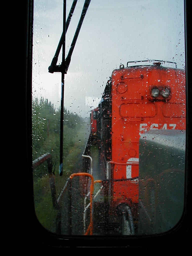The view looking forward from the trailing GEC Alsthom unit as we head eastbound into some heavy rain on the Caramat Sub. with the CN 5647 leading. Note - Exact location approximate, somewhere east of Longlac.