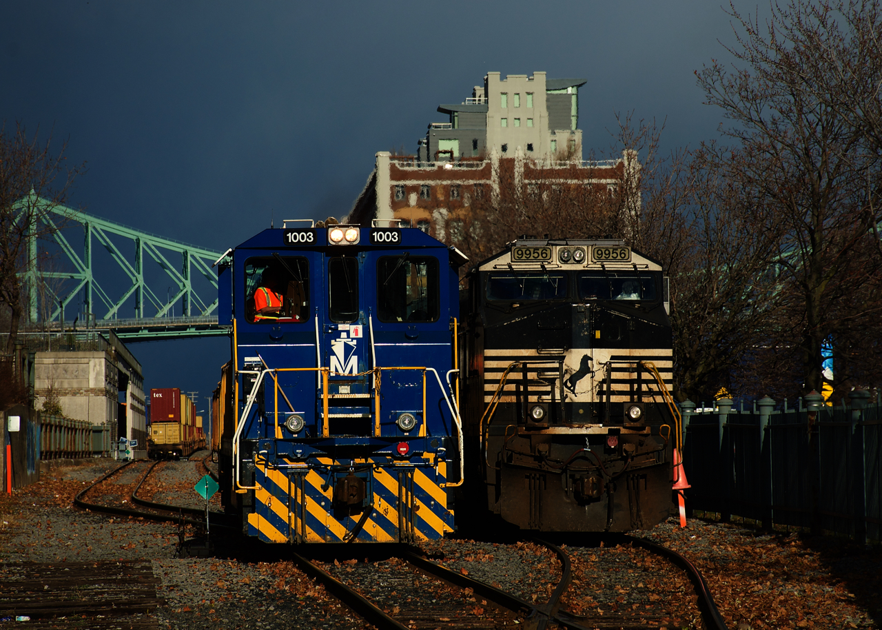 In a rare encounter, a Port of Montreal job is backing up after bringing the intermodal cars at left here. Meanwhile CN 543 with NS power at right waits for the switcher to clear so it can back up to the intermodal traffic. A brief period of sun lights up the scene..... just ten minutes earlier it had been hailing!