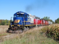 RLK 4001 and GEXR 3821 lead a train southbound on the Exeter Sub. on a beautiful Fall day.  Photographed at Roman Road between the dots on the map known as Vanastra and Brucefield. Now fifteen years later, both locomotives are still with us in Southern Ontario.  RLK 4001, with the Rail America logo on the nose and Lakeland & Waterways logo on the hood painted over, is assigned to Southern Ontario Railway operating out of Garnet / Nanticoke.  GEXR 3821 went off for rebuild and returned as GEXR 2073 in Genesee & Wyoming orange and black.