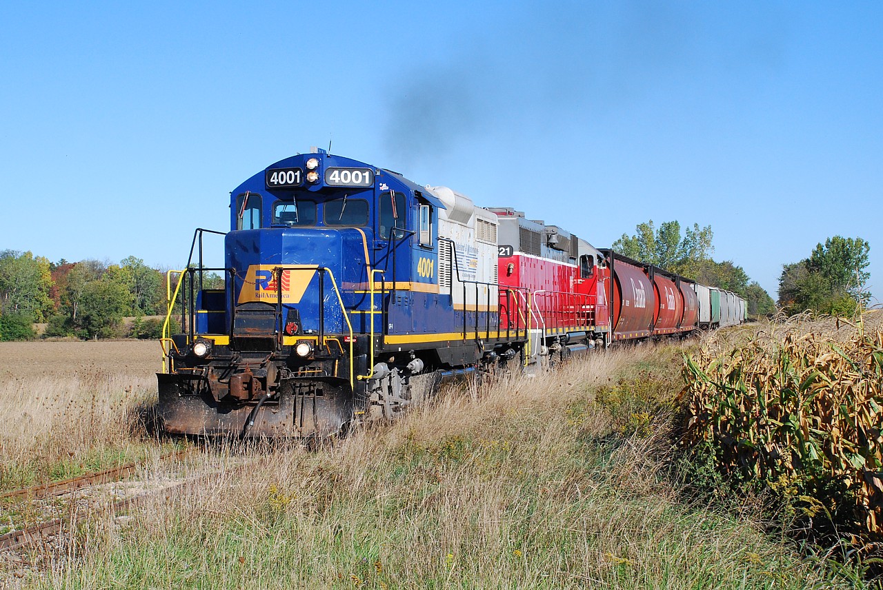 RLK 4001 and GEXR 3821 lead a train southbound on the Exeter Sub. on a beautiful Fall day.  Photographed at Roman Road between the dots on the map known as Vanastra and Brucefield. Now fifteen years later, both locomotives are still with us in Southern Ontario.  RLK 4001, with the Rail America logo on the nose and Lakeland & Waterways logo on the hood painted over, is assigned to Southern Ontario Railway operating out of Garnet / Nanticoke.  GEXR 3821 went off for rebuild and returned as GEXR 2073 in Genesee & Wyoming orange and black.