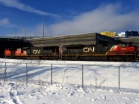 CN 120 emerges from underneath the Turcot Interchange with an EMD trio up front (CN 8912, CN 5653 & CN 8873) and a fourth EMD unit mid-train (CN 8888).