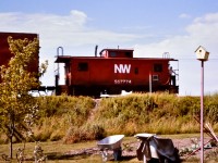 With the head end captured in a previous post, http://www.railpictures.ca/?attachment_id=50588 here is the tale end of the same westbound N&W freight scooting along the Cayuga Sub. through Jarvis ON in the summer of 1976.  Caboose NW 557774 is carrying the markers today. Just like the headend crew, one of the tail end crew members stands on the rear platform ready to acknowledge any of us that might be out in my parents back yard. The west backtrack switch, the restricted clearance sign for the elevated freight shed platform at the mill, & the pole line wires are clearly visible along the right-of-way. The wheelbarrow and garden tools by the well tilled garden belong to my dad, a.k.a. the CN Roadmaster stationed in Jarvis at the time. My parents house was less than a hundred feet from the Cayuga Sub. which, unknown to us at the time, was a treasure trove of railroad action waiting to be photographed. That worn path up the side of the hill now leads to a much larger trail where the Cayuga Sub. once was. Norfolk & Western is no more. The Cayuga Sub. is no more. And the garden is no more. :-( My how things change!




