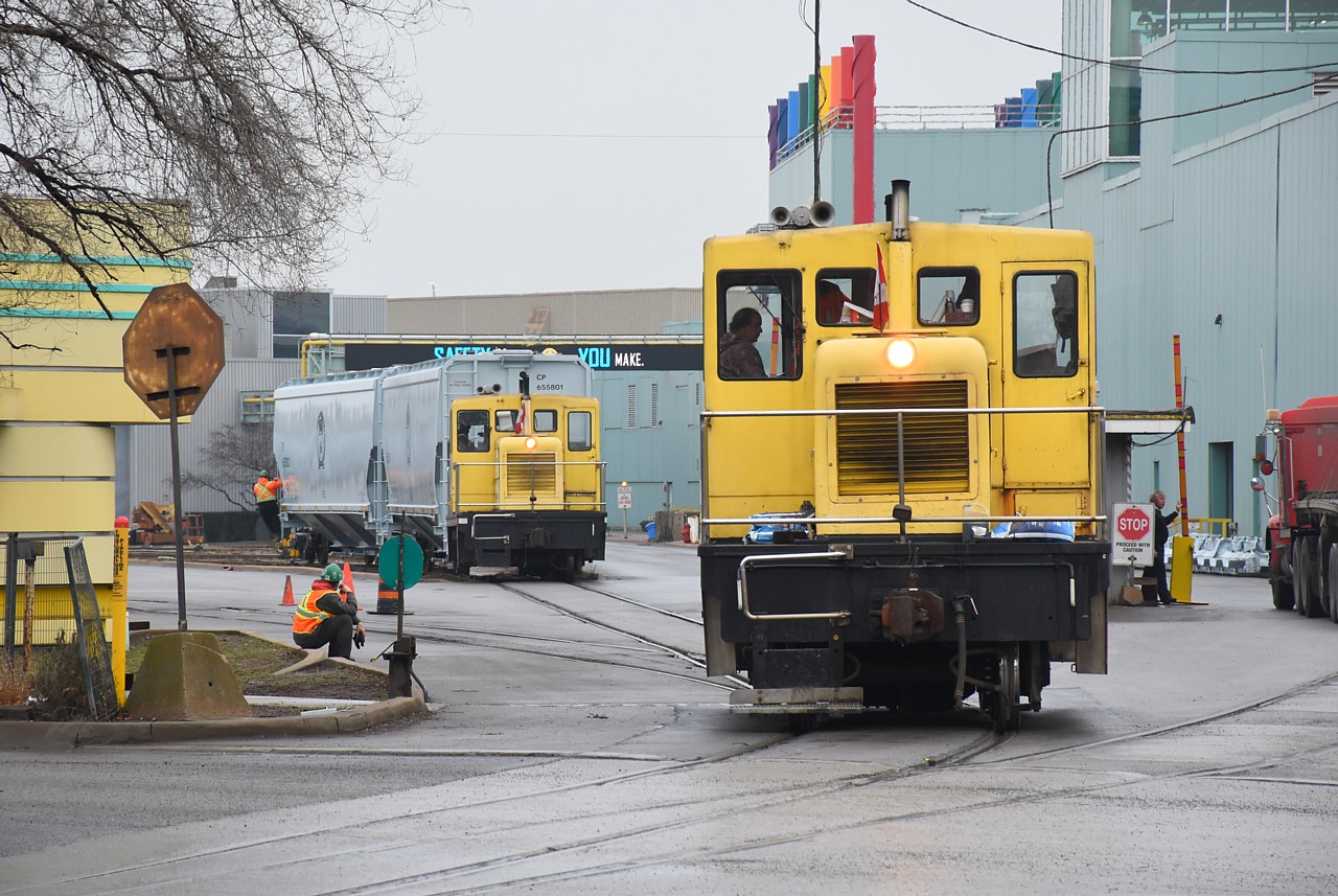 The crew using NSCX 11 takes a break while NCSX 12 switches two CP hoppers around in the distance.  From this angle they look the same, however #12 has angled white stripes on the sides of the hoods, whereas #11 does not.  No sign of the SW1001s today.  Shortly after I took this photo, CN came in to lift new TCMX hoppers and NKLX coil cars, the highest car number being NKLX 400096 for those keeping track.