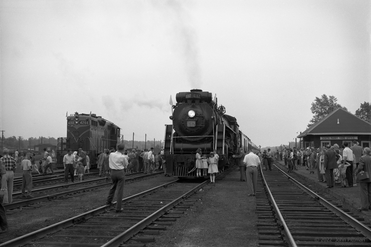 Canadian National ran excursions behind their 4-8-4 class U-2-e steam locomotive CN 6167 from 1960 until 1964.
Here is 6167 at the furthest stop of the Toronto Union to South Parry (and return) excursion of 10 June 1962. 
Details more evident at full size include 2 boys climbing the cab steps, and a crewman in overalls on the platform.
CN 6167 was built by Montreal Locomotive Works in March 1940, working in freight and passenger train  service with CN until 1959.  
Its most dramatic day was 6 July 1943 when it was seriously damaged in a tragic fatal collision.
If not for the wartime conditions, 6167 would likely have been scrapped rather than repaired.  
Reactivated for excursions in 1960, its last run was September 28, 1964.  CN 6167 was donated to Guelph in 1967. 
For more information:
https://www.ghra.ca/railway-history/canadian-national-railway-6167/