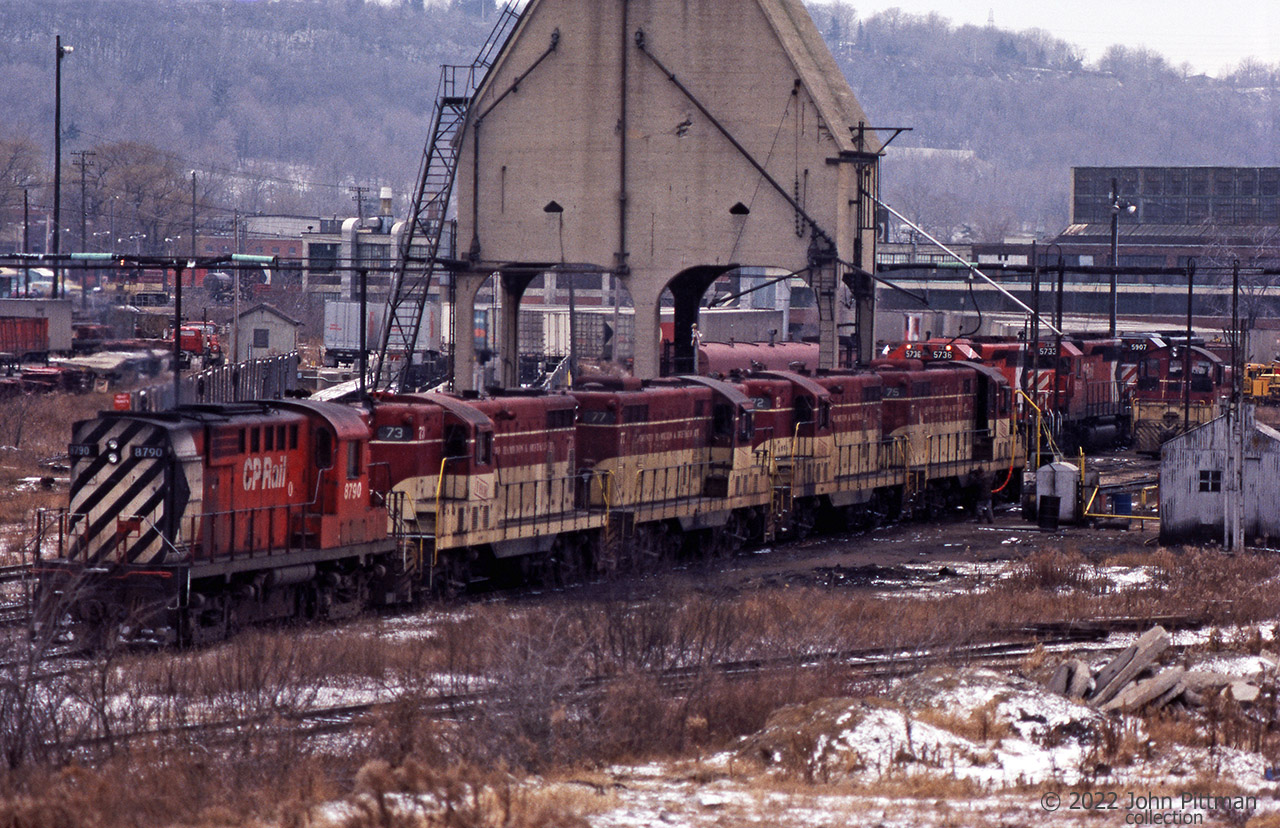 Late winter scene at TH&B Chatham Street engine tracks.
Apparently the coaling tower has a continuing role, supplying locomotive sand.
RS-18 CP 8790 is the only MLW visible, coupled with 4 of the remaining TH&B GP7 locos.
Looks like TH&B 75  at the other end is being re-fueled.
Multimark SD40-2 units CP 5736, 5733, and 5907 are two tracks over. 
There are 2 TH&B switchers in the picture, the one further away has its headlight on.