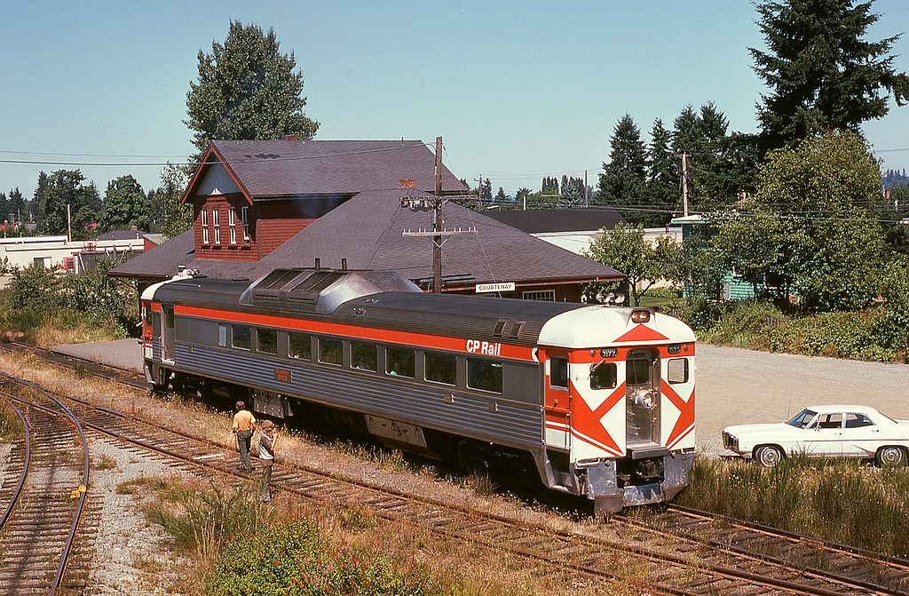 Just getting underway for its 139-mile run back to home base at Victoria, Budd/CC&F RDC-2 9199 is leaving the depot at Courtenay on Friday 1974-08-02, on time at 1300 PDT, in a view from the top of a boxcar spotted on the spur as seen on the left.