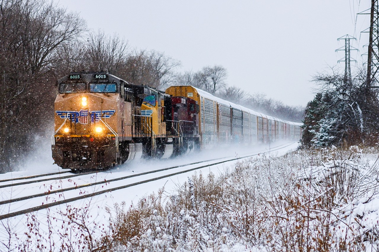 A foreign power duo third wheeled by a CP AC44 leads CP 234-12 during an early January snow squall. Having a short train made it easy for the train to pick up speed and kick some snow after holding at Davenport for a Newmarket GO Train.