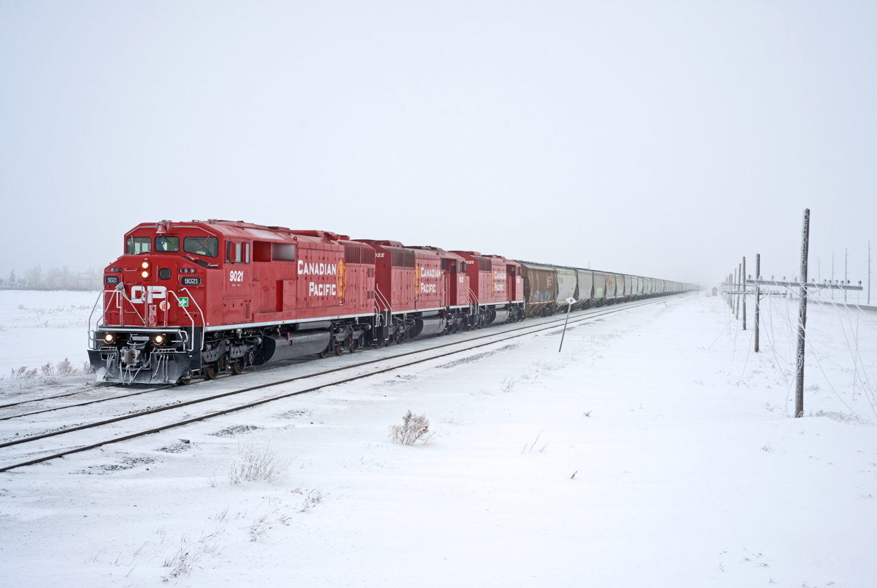 CP# E07-14 departs an ice fog covered Regina with a trio of consecutively numbered SD40-2Fs up front, and 6600ft of grain in tow.