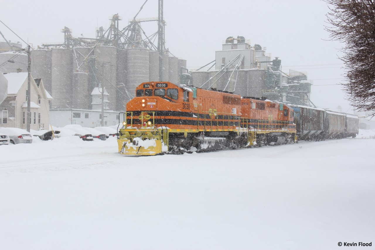 In December 2016, off and on heavy snowsqualls were pummeling Huron County as the local GEXR train approaches Hensall on the Exeter Sub to complete some switching at the feed elevators.