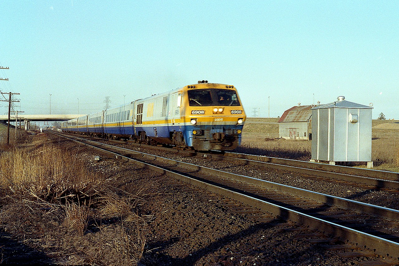 Late day scene; I don't recall VIA #75 powered by LRC-only so not sure what number this passenger is. But it is westbound. One of a rather unreliable fleet of BBD locomotives, this LRC-2 6908 was sold to CAD Rail Services in 1999; renumbered as their 2000 and scrapped in 2003.
No doubt this location pictured will be puzzling to some locals.  That is a QEW bridge in the background, and the barn was razed for the future IKEA complex that now occupies this once fertile field.
