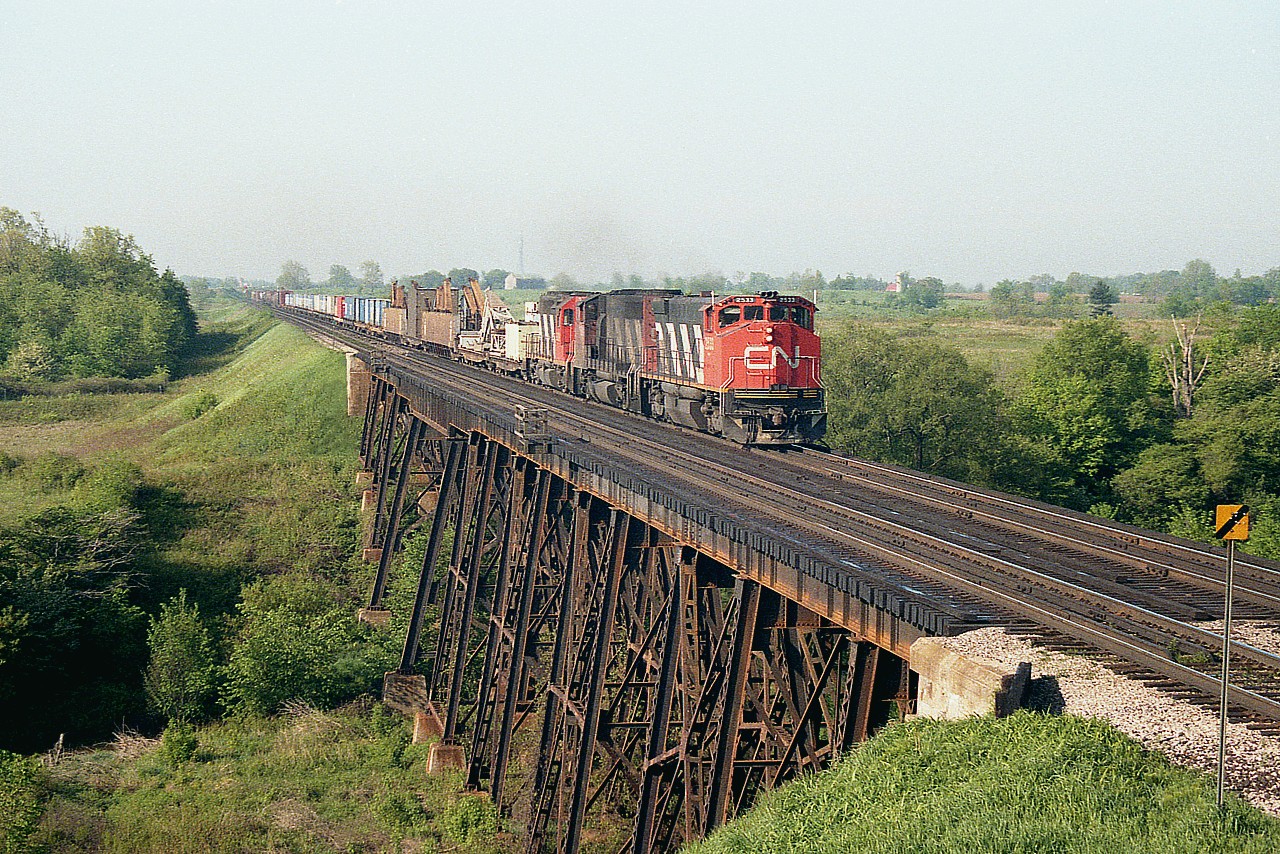 Yes, I suppose this isn't really Lynden West but I've called it that for so many years.........and to me it is not Brantford. The bridge over Fairchild creek was a great spot for photos many years back. I suppose it still is, but I'm too lazy to hike in there and see how it is these days. On the first day of June almost 39 years ago this was idyllic a setting as there was being trackside; just plopped against a rock or a log and snoozing away the morning with scanner in hand. Now, of course.......there's ticks....and other annoyances....one of those being very few trains. CN 2533, 9583 and 9309 are eastbound with 98 cars and caboose 79748, so my notebook reads. Leader 2533, an MLW M-420, was renumbered 3533 in 1986 and then went to Hudson Bay Rwy along with a number of other units in the series. CN 9583 ret'd in 2000 and GP40 9309 sold to RLK, keeping same number; and retired shortly after.