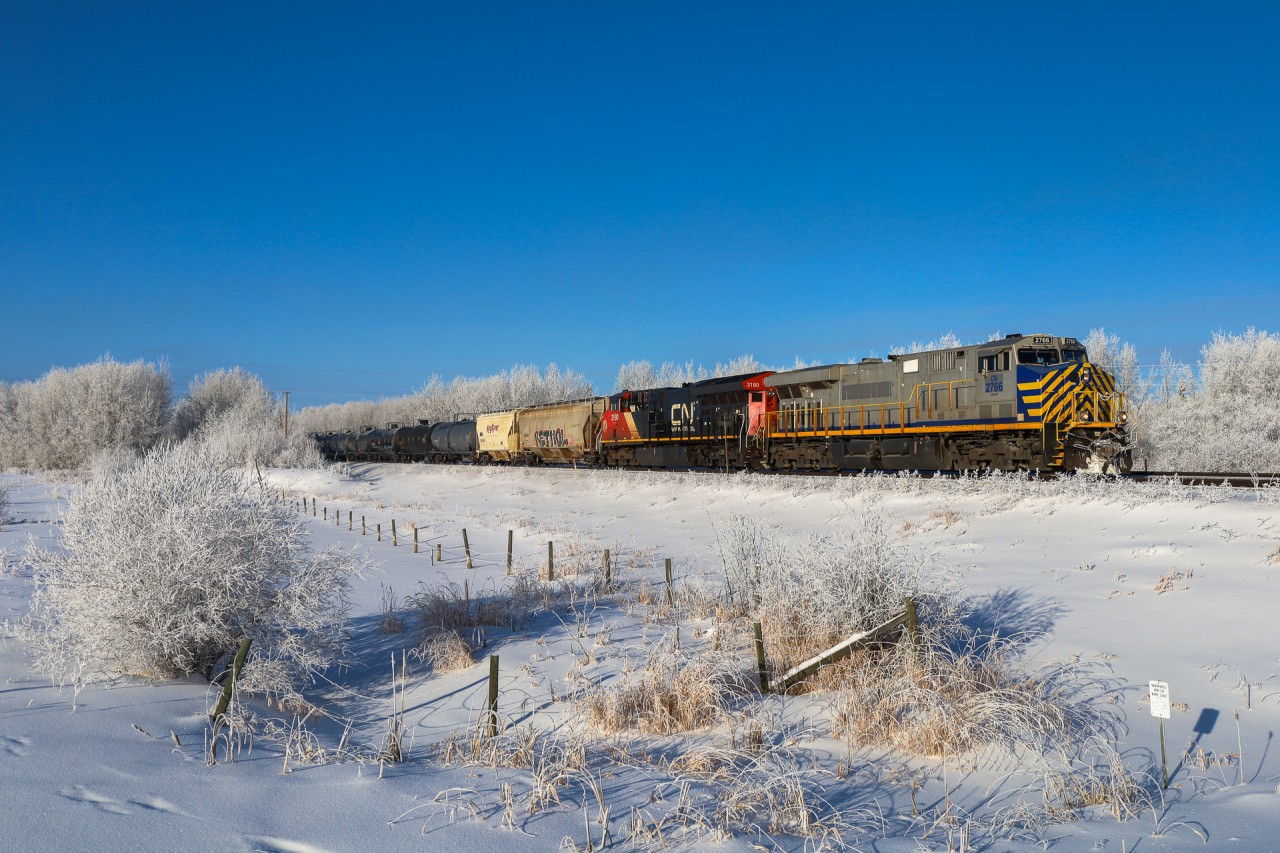 While Edmonton is shrouded in a think layer of ice fog, just outside of the city is enjoying beautiful sunny weather.  A 40251 30 gets under way through a hoar frost covered landscape with CN 2776 on the point.
