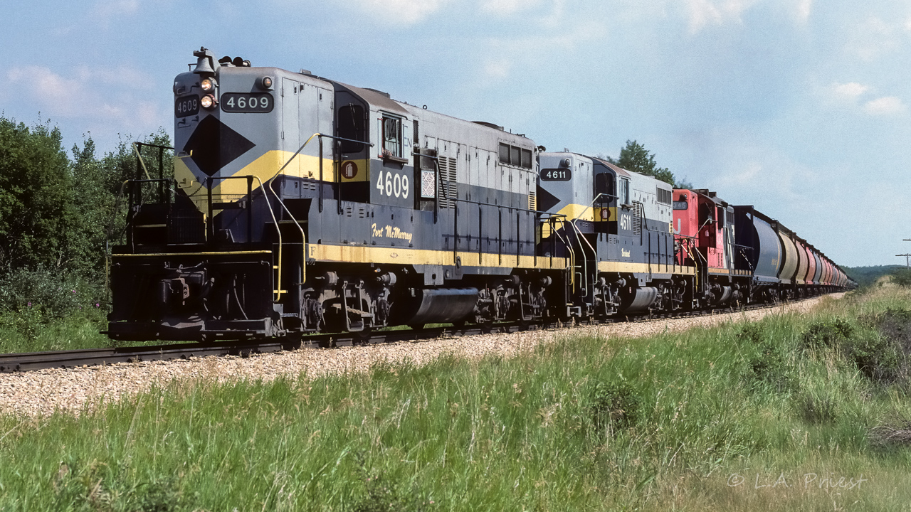 Nearly at the top of the hill from the Redwater river, 836 will soon be getting the switch at Kerensky to continue the trip to the air base. There must be a lot of flying scheduled, there are 34 tanks of fuel behind those 14 empty hoppers. You can see the 2 trailing units are working, even a little smoke from the 4345. For whatever reason (you can see the open hood door on the 4609), the lead unit on the way out, and, back again the next day, was not in operation. Nice quiet ride for the headend crew, just swooshing of air brakes. They are a little late today at 15:45, typically roll through just before lunch.