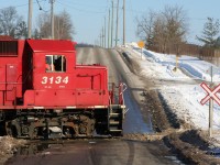 An Extra CP Wolverton Job with 3134, 3117 and 3045 is switching over Greenfield Road in Ayr, Ontario on the Ayr Pit Spur during a winter afternoon. 