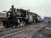 As it was mentioned in the comments on <a href=http://www.railpictures.ca/?attachment_id=50889>John Freyseng's shot of 5107,</a> here is a shot of the joint Upper Canada Railway Society and Canadian Railroad Historical Association trip behind E-10-a 2-6-0 90 and N-4-a 2-8-0 2649 at Bancroft.<br><br>Departing Belleville amid the light rain that morning at 0645h - with a crew from the National Film Board setup in the baggage car - the excursion ran along the Campbellford Subdivision to <a href=http://www.railpictures.ca/?attachment_id=46380>Anson Junction,</a> taking the east leg of the wye onto the Maynooth Subdivision.  The train would pause briefly at Bancroft before proceeding three miles north to York River where the train could be wyed for the return trip.  Arriving back at Anson Junction, the excursion would continue south into Trenton, turning on the wye before returning north to Trenton Junction to rejoin the Oshawa Sub mainline for the short twelve mile run back to Belleville.  The special reached a top speed of 55mph on the high iron, running barely 30 minutes ahead of Toronto - Montreal train 6, due into Belleville at 1815h.<br><br>Notes of the trip per John Freyseng's extensive article in the June 1959 UCRS newsletter.  Neither of these locomotives would last another year, with 90 meeting the torch in February 1960, and 2649 that March.<br><br>Original Photographer Unknown, Al Chione Duplicate, Jacob Patterson Collection Slide.</i>