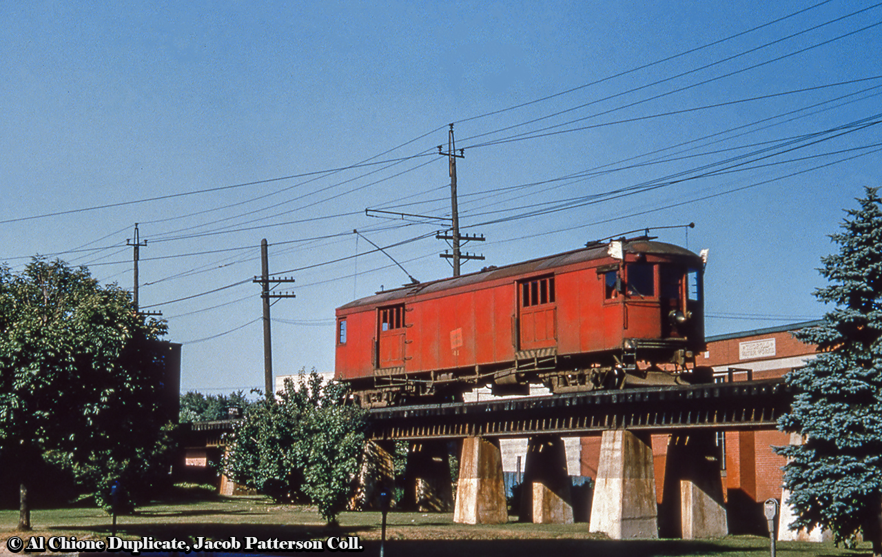 Niagara, St. Catharines & Toronto Railway express motor 41 runs northbound passing the Thorold Water Works on the elevated tracks at Front and Regent Streets.  Purchased from the Cleveland, Painesville & Ashtabula as motor 60 in 1927, 41 would leave the property in 1959 along with numerous other pieces of NS&T equipment destined for the reclamation yard in London for scrapping.Original Photographer Unknown, Al Chione Duplicate, Jacob Patterson Collection Slide.