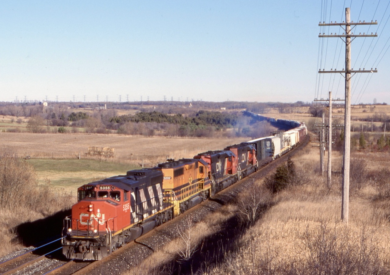 It really wasn’t that long ago that 3000hp locomotives dominated a large percentage of mainline freight trains. Even into the 2000’s SD40’s and 4 axle cousins the GP40’s were still a common sight. Today 4300hp and 4400hp locomotives have taken its place. This days CN train 305 has wide cab SD40-2W 5355 up front with SLA GP40-2 3202 as well as a CN SD40U and former UP/MP SD40-2. The train is seen rolling through the popular railfan spot at Newtonville.