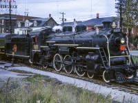 The weekend of October 13-14, 1962 provided railfans in the Montreal area with two excursions out of Central Station behind two steam locomotives. The Saturday trip would be led by J-4-d Pacific 5107, and the Sunday trip double headed with 5107 and U-2-c 6153. These trips run by the Canadian Railroad Historical Association were supported by the Upper Canada Railway Society.<br><br>CNR 5107 is seen sitting to the north of CN's Richmond station during a water stop while en route from Montreal - Sherbrooke. The six car train had departed Central station track 9 that morning at 0829h making a water stop at St. Hyacinthe and three photo runpasts. One more runpast would be held between Richmond and Sherbrooke before turning the train for the return to Montreal, stopping for three more runpasts and water on the way. Back in Montreal, 5107 would be cut off at Bridge Street, leaving the consist in the care of MLW S4 8062 for the last couple of miles into Central Station. Today the Sherbrooke sub is operated by the St. Lawrence & Atlantic Railroad, and CNR 5107 is on display in Kapuskasing. Bill Thomson caught <a href=http://www.railpictures.ca/?attachment_id=15145>5107 at Mimico</a> in the summer of 1958.<br><br>Directly across from the station on Rue Principale Nord (Main Street North) sits the Hotel Brunswick. Built circa 1910, the hotel served many travelers over many decades. Like the former station, now a restaurant, the building serves a new purpose today, as the Résidence Brunswick, a retirement home. Michael Berry's <a href=http://www.railpictures.ca/?attachment_id=19228>2015 shot across the Richmond yard</a> gives viewers the station at centre with the Brunswick off to the left.<br><br>Scanning and editing by Jacob Patterson.