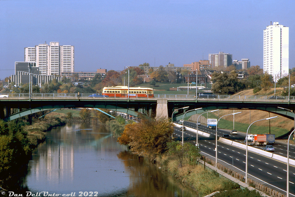 Trundling eastbound into East York, a TTC PCC crosses Gerrard Street bridge in traffic, passing over the Don River and Don Valley Parkway below. In the background is Riverdale Park East, numerous apartment buildings along Broadview and Cambridge Avenues, and the Parkway Vocational School (today's City Adult Learning Centre) on the left.

Original photographer unknown, Dan Dell'Unto collection slide.