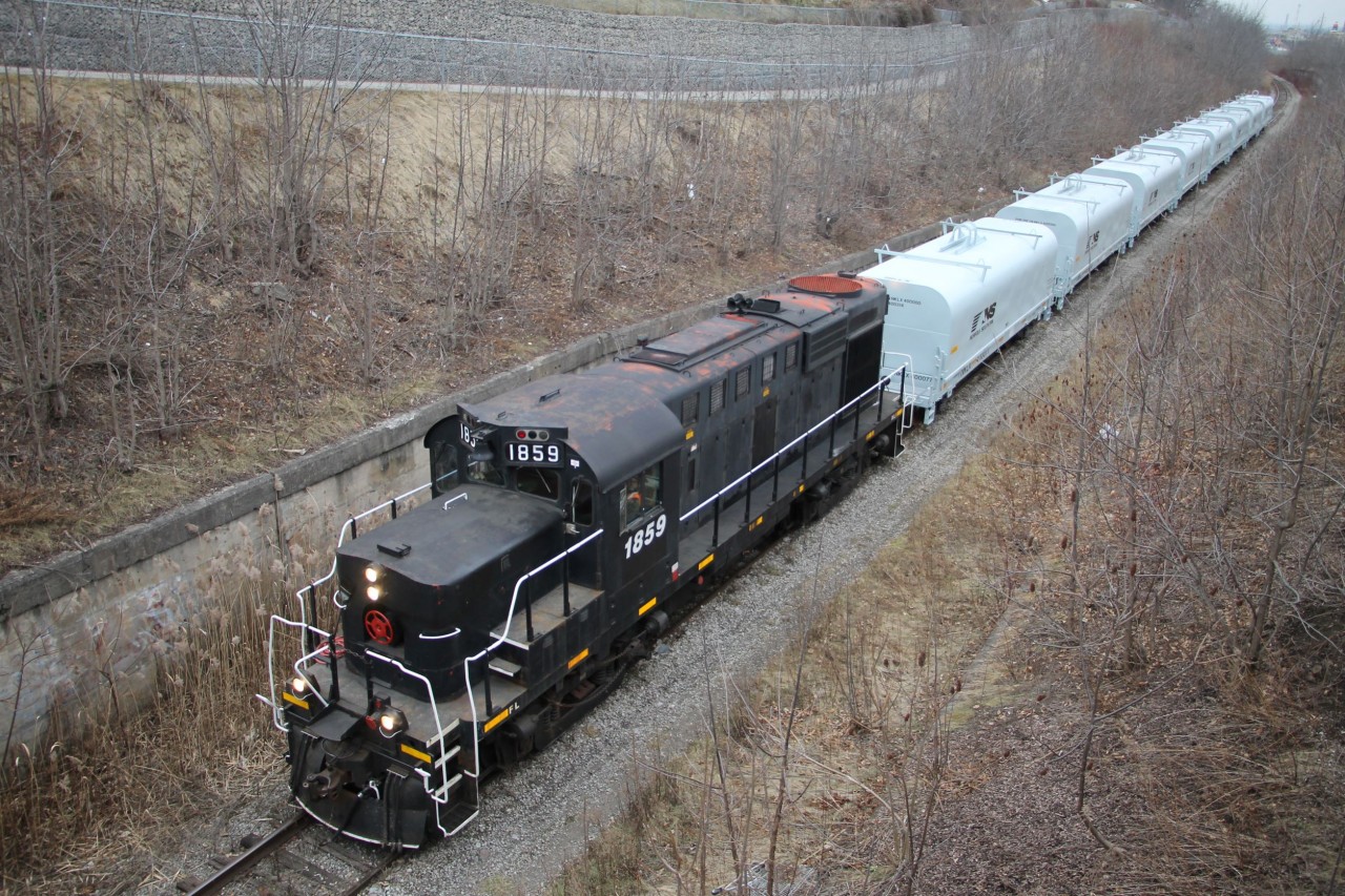 With original CP red showing through GIO (TRRY) 1859 with eight New NS coil cars slowly make their way up the Niagara Escarpment alongside the Welland Canal at Lock 7. The Conductor gives a quick look up before they pass under the Welland Canals Parkway at Mile 5.90 Thorold Spur. They will continue south to interchange the NS cars presumably with CP.