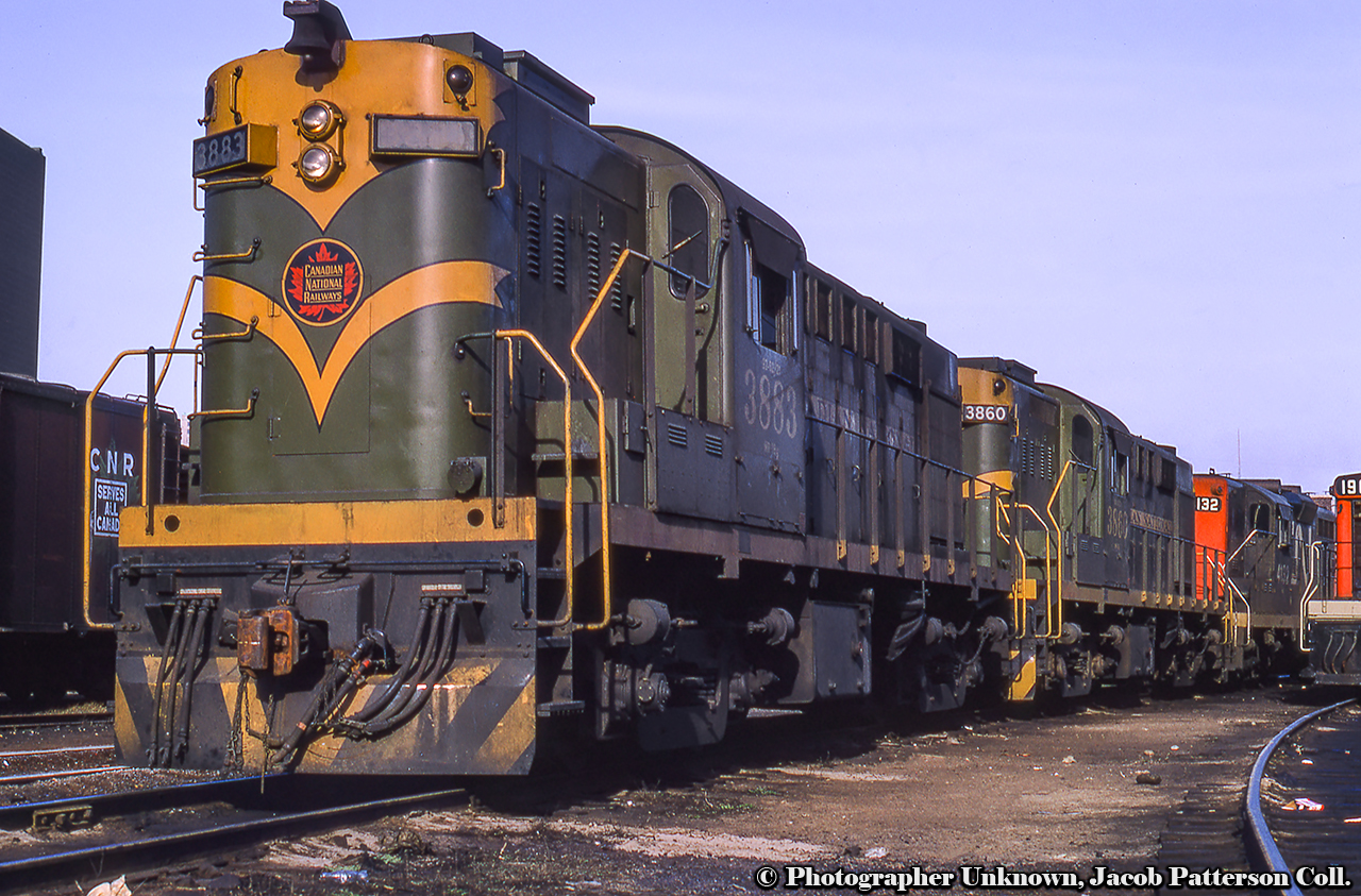 Shop tracks at Spadina are filled with first generation motive power, including a pair of recently rebuilt CN RS18ms in their patched green and gold scheme.  Six RS18s (3850, 3856, 3860, 3883, 3884, 3887) received Cummins head end power (HEP) units in their short hoods in addition to dual control stands during 1967 rebuilding for Tempo service in southern Ontario.  The well known orange and white Tempo scheme and their new numbers would be applied late in the spring of 1968.  CN 3883 became CN 3151 while CN 3860 became CN 3153.  Both of these units would lose their HEP equipment in a fatal wreck at Woodbine on the Weston Sub in April 1969 requiring them to use baggage cars equipped with HEP equipment for their trains.With Tempo coaches beginning to arrive during spring 1968, employees were given two round trip introductory runs on Sunday, June 9, 1968 between Toronto and London before service began on Monday, June 17.  Tempo equipment would initially be assigned to trains 147/142 running Toronto – Windsor, and trains 151/150 running Toronto – Sarnia.  Wednesday, July 10 would expand the equipment to Windsor trains 141/146.  Power in the background includes GP9 4132, and GMD-1 1907 at right.Also at Spadina, Dave Burroughs captured CN 3887 in this pre-Tempo stage during May 1968.Original Photographer Unknown, Jacob Patterson Collection Slide.