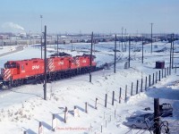  Taken from the third floor GYO washroom window, a set of hump power 1502-1537-1519 passes over the main retarders heading down into 'C Yard' after humping a cut at Toronto Yard (Agincourt) on a chilly Feb 18th 1990. 
1502 is adorned with the Toronto Yard 25th Anniversary stencil. The hump and associated 72 yard tracks is all gone now.  