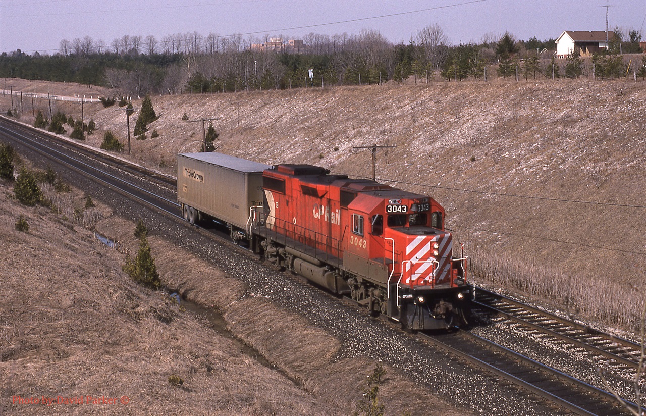 CP 3043 leads a very small No 528, consisting of just the Triple Crown adapter car passing through Coakley on the Galt Sub March 31st 1992. Not sure why the lack of traffic, suspect the connecting train at NS Oakwood Yard (Detroit) was late and they would require the power and adapter for the Westbound train out of Lambton that afternoon.