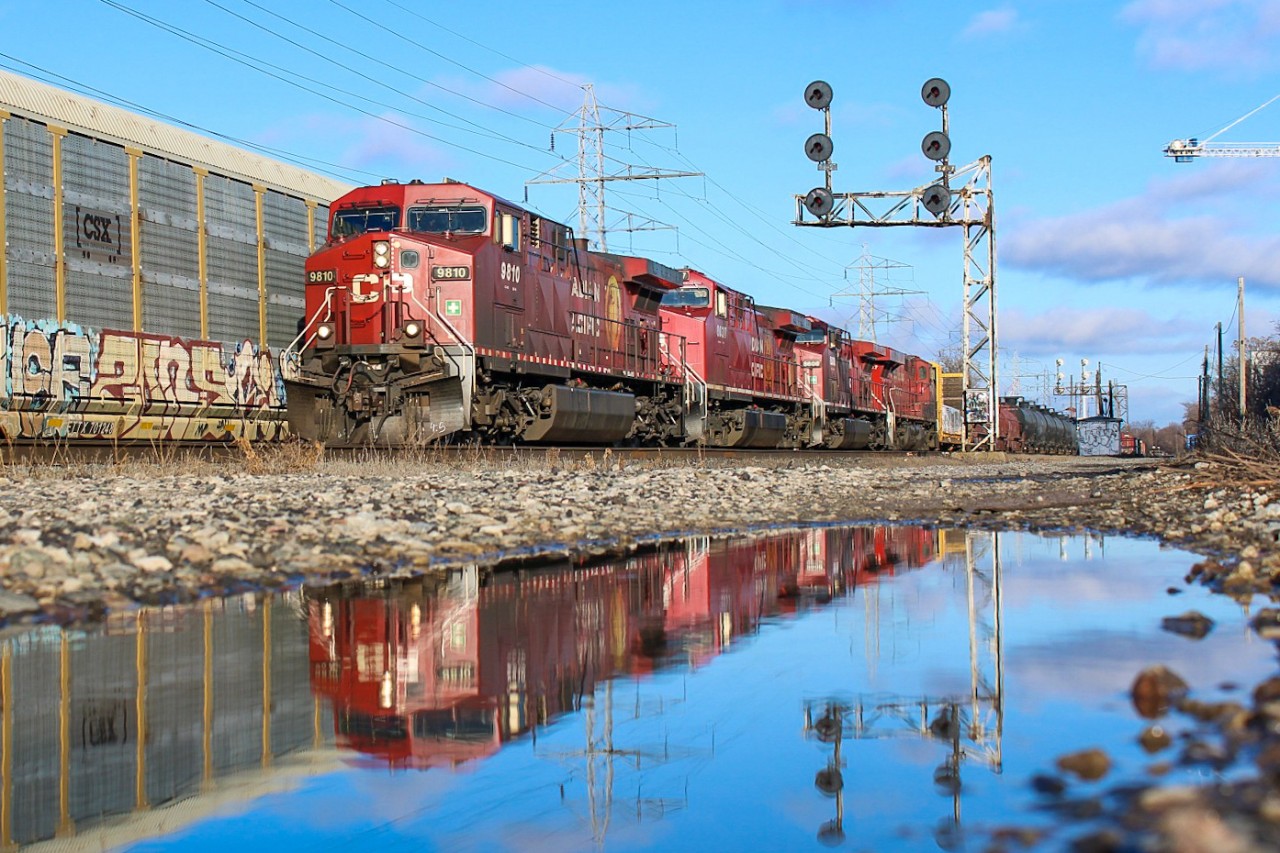 With the typical presence of meltwater after a recent snowfall in Toronto, I spotted a well-placed puddle west of the Howland signals. Using the digital viewfinder on my DSLR to keep the camera at ground level, I only had enough time to grab one shot of the fast-coming 421. Being a partly cloudy day with some shadows just metres away, I was lucky to get full sun and a relatively tolerable leader to boot.