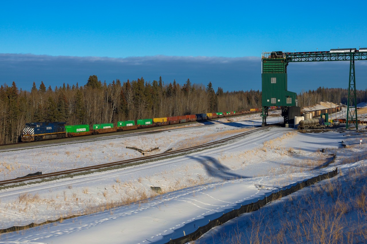 Montreal to Vancouver Q 10521 05 highballs past the Coal Loadout at Pedley, just east of Hinton, Alberta
