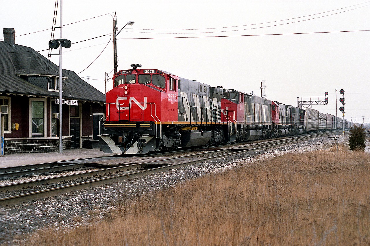 Spiffy assortment of power on this eastbound as it rolls by the old Burlington West station, once known as the Freeman station. In consist is CN 2575, 2100, 2309 and 9468. Models MLW M-420, BBD HR616, MLW M-636 and the once common GMD GP40-2L.  (The 9468 is now on the roster of DMVW).
My assumption that this is 434 is based on the fact very few freights other than 434/435 operated east of Burlington on the Oakville sub. Nice clean paint job on the leader!