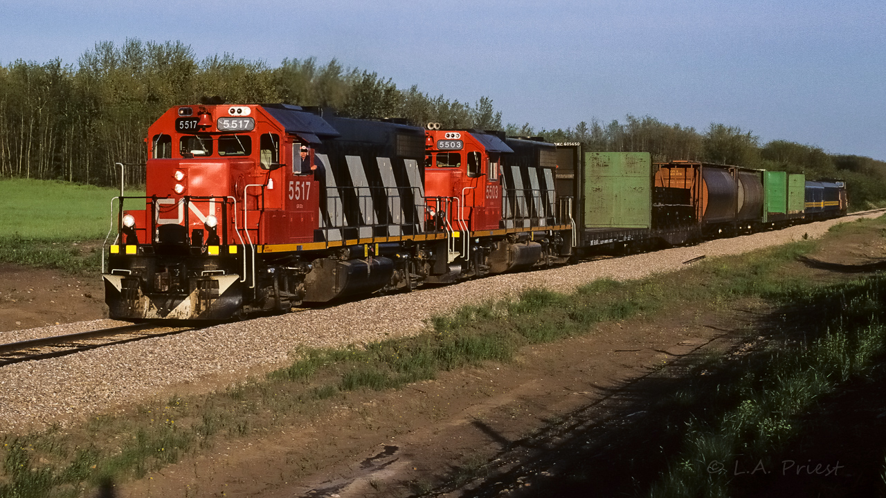 A short Muskeg Mixed makes it easy to frame fit. :^) The units are fresh and crispy tonight. Looking into my notes, the 5517 I first spotted in stripes Sept.86 and the 5503 with hers in March 87. Lucky chance to have them both headed in the same direction. That is Baggage 7856, Coach 5095 and Caboose 79881 at the rear. It is just a short distance to the connecting track where the Lac La Biche Sub. will take the mixed train north.