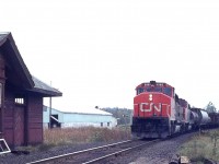 The old Mount Albert passenger station was closed to business in the mid 1960s. It was then converted to an office and meeting place for work crews along the line.  In 1977 it was moved to Cannington Community Center and is now preserved; strangely enough with Cannington namesigns and not Mount Albert.
It is a wonder the station survived. When I visited on this day it was thoroughly trashed by vandals over the years. Inside and out.  While I was there a northbound freight happened upon the scene, led by CN 9585. Nice to see the station was a survivor. You can see a bit on the left how much it had been damaged. It is a wonder it was not torched.